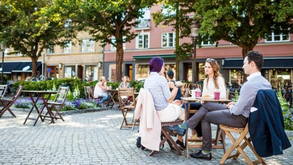 Junge Menschen sitzen in einem Cafe auf dem Dorfplatz