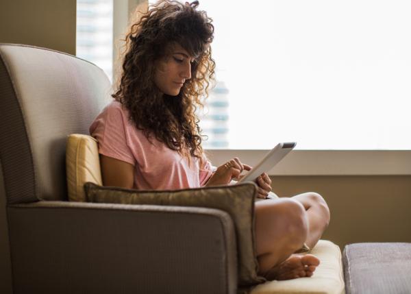 Frau sitzt zu Hause in einem Stuhl