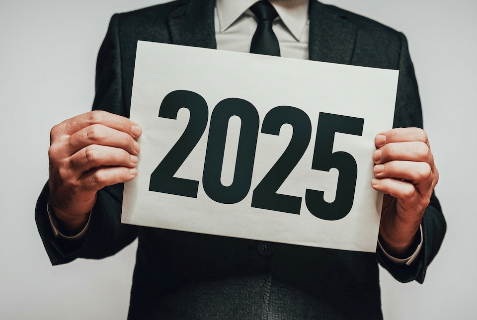 Geschäftsmann hält ein Plakat mit 2025 vor sich