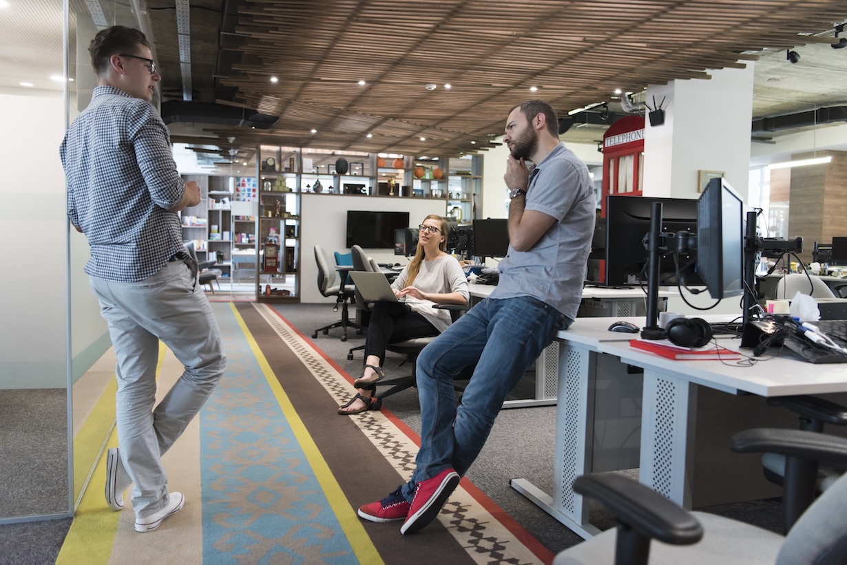 Drei Büroangestellte in einem entspannten Gespräch