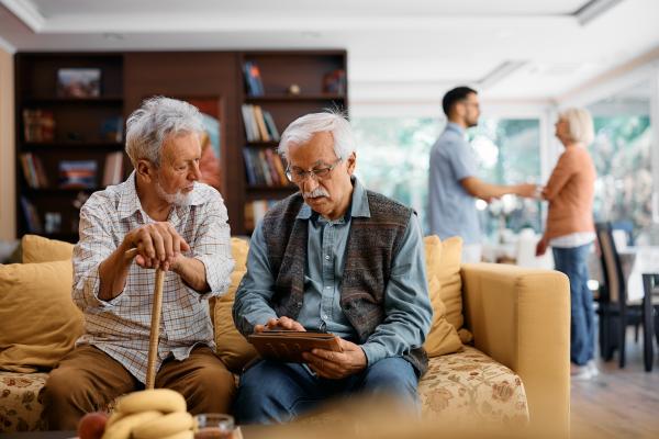 senior male friends using digital tablet at nursin 2023 11 27 05 36 51 utc